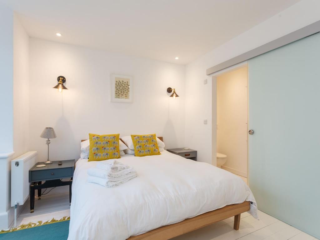 伯恩茅斯Dale House - Vivre Retreats的卧室配有一张带黄色枕头的大型白色床。