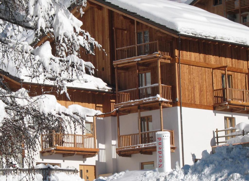格雷索拉特里尼泰诺尔登德酒店的一座被雪覆盖的建筑,有雪覆盖的树木