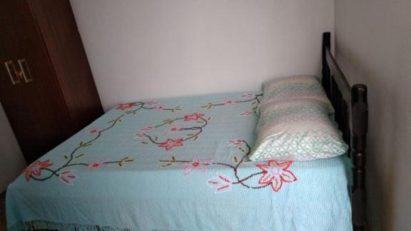 纳韦甘蒂斯Hospedagem Navegantes的一张带鲜花的蓝色棉被的床
