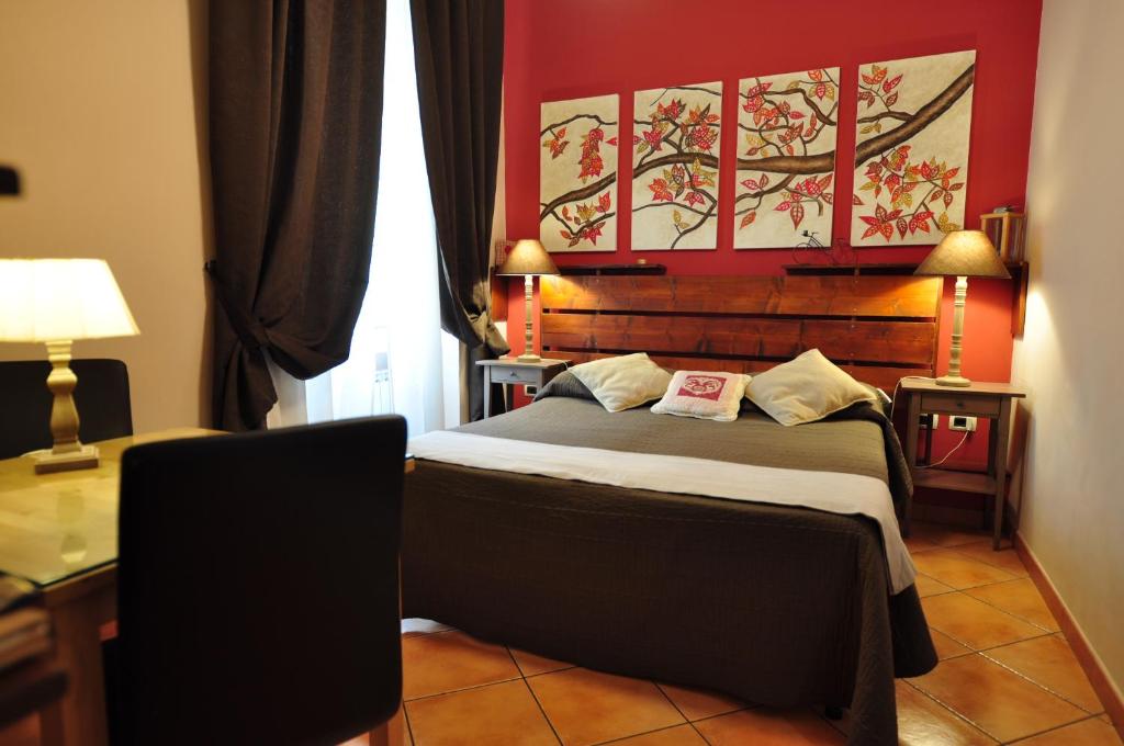 罗马可丽贝的一间卧室配有一张红色墙壁的床
