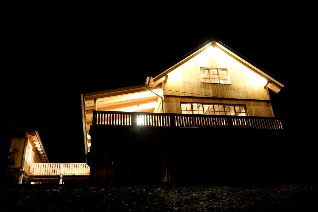 施马伦贝格Romantikhütte Rothaarsteig的夜晚,房子的一侧有灯
