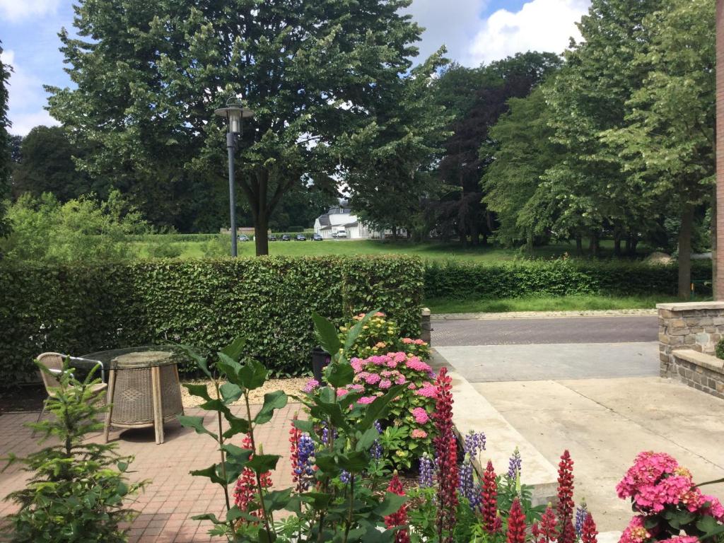 GenoelselderenBelle Vue Vakantieappartement的公园里种着鲜花和长凳的花园