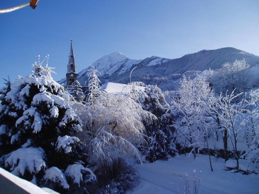 圣雷热雷梅累兹Les Garianes的一群被雪覆盖的树木,一个教堂