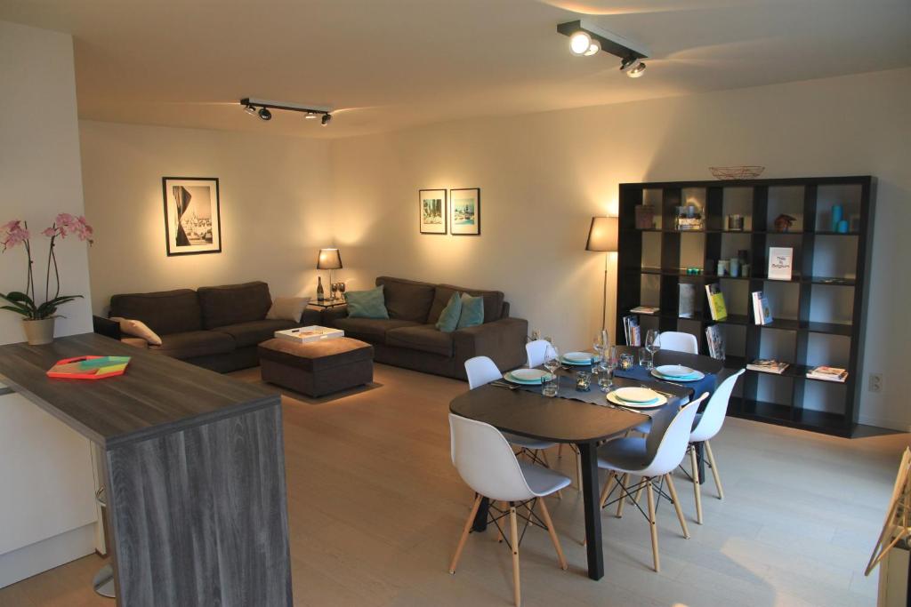 布鲁塞尔布鲁塞尔新设计公寓的客厅配有桌子和沙发