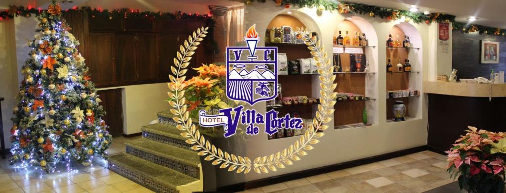 Xicotepec de JuárezHotel Villa de Cortez的圣诞客房,带圣诞树和标志