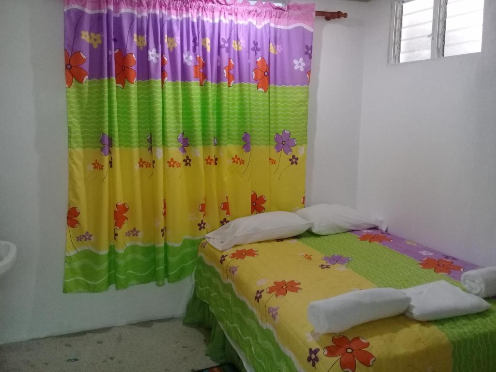 哈拉瓦科阿Hostel Quintonido的一间卧室配有一张带色彩缤纷窗帘的床