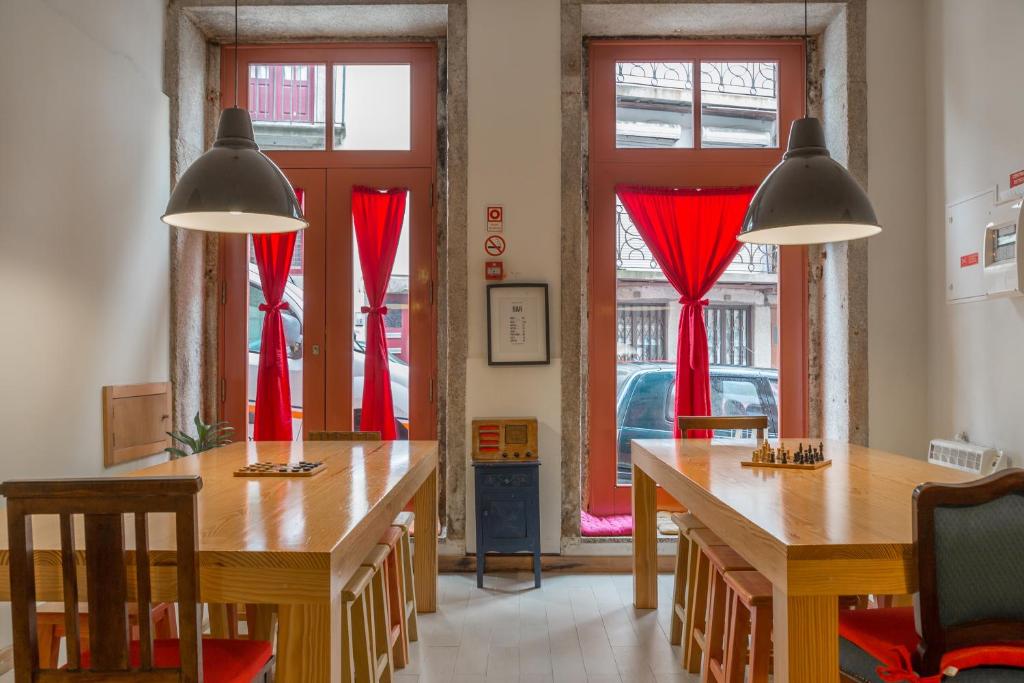 波尔图帕伊茨酒店的一间设有两张桌子和红色窗帘的用餐室