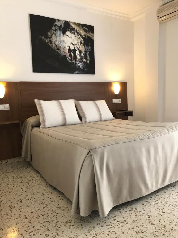 阿达莱斯埃尔克鲁塞餐厅旅馆的一间卧室配有一张大床和两个枕头