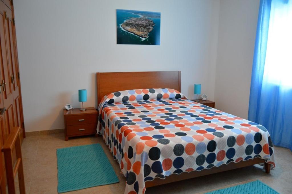 佩尼契Apartamento na Cidade do Surf的一间卧室配有一张带五颜六色棉被的床