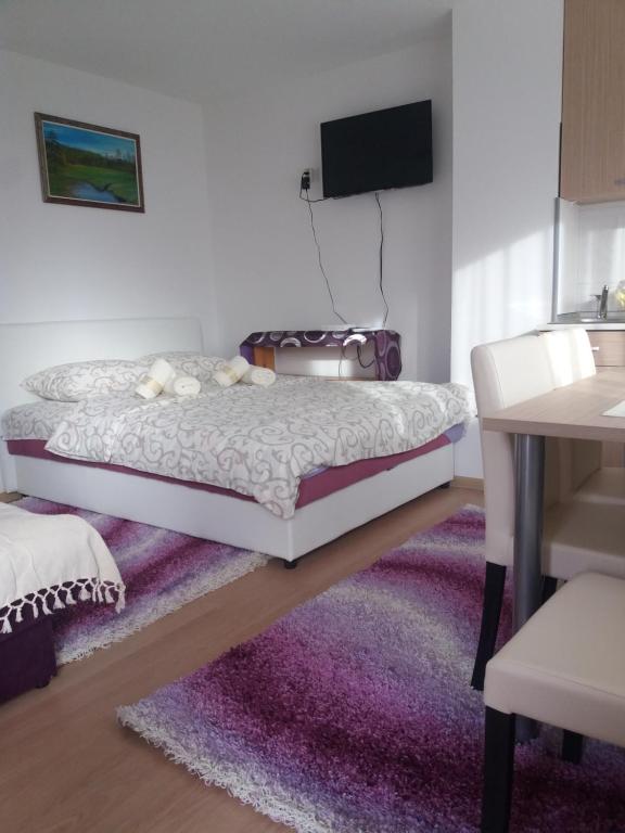 兹拉蒂博尔Apartment Bućić的一间卧室配有一张床和紫色地毯