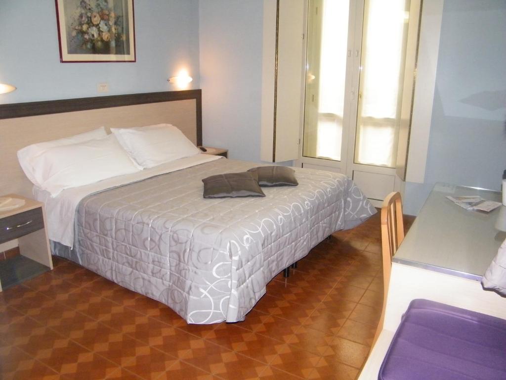 都灵Hotel Alba Torino centro的一间卧室配有一张床、一张桌子和一个窗户。