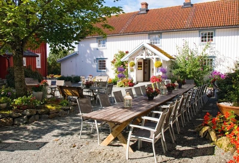 TautraKlostergården Bed & Breakfast的白色建筑前的一张木桌和椅子