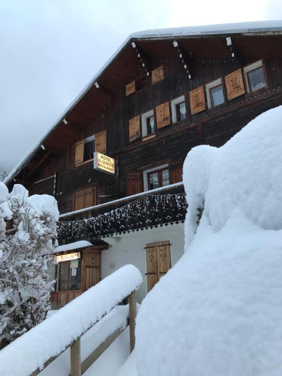 莱孔塔米讷蒙茹瓦盖里纳特酒店的一座被雪覆盖的建筑,有栅栏