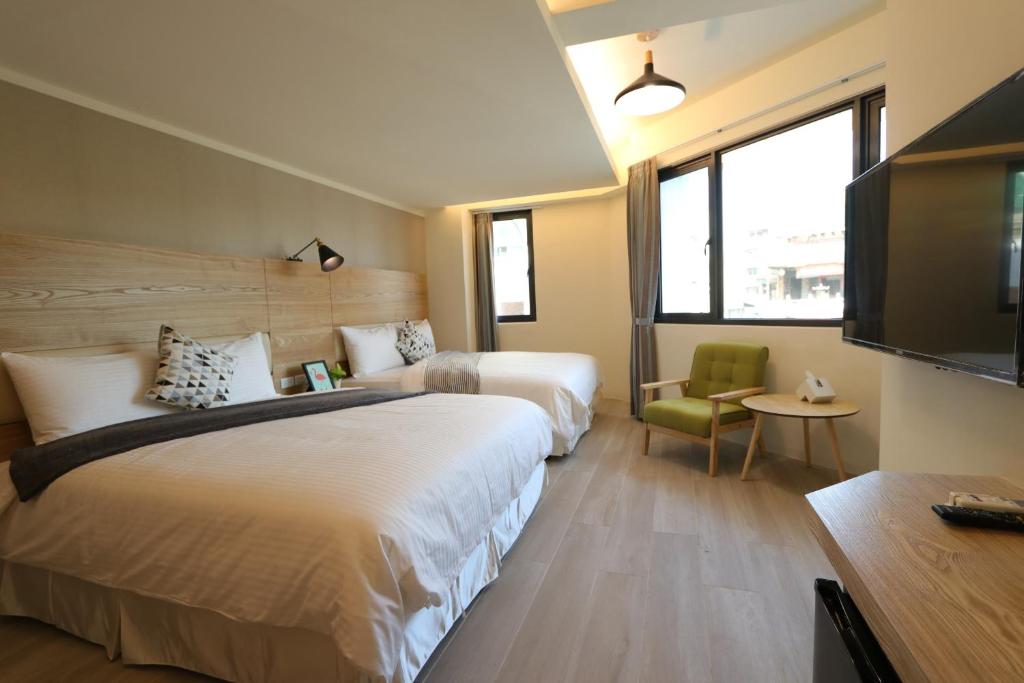 安平区花水木民宿 的酒店客房设有两张床和一台平面电视。