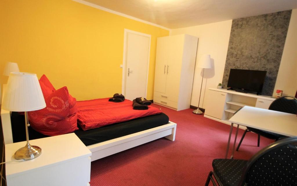 汉堡Sleep in Hamburg St. Pauli的一间卧室配有一张带红色枕头的床和电视。