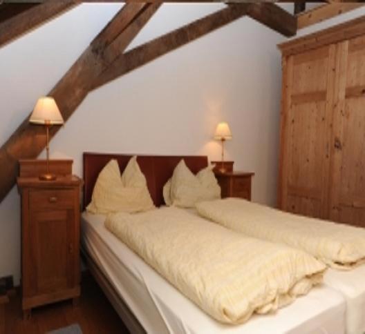 拉纳哈本加特公寓的一间卧室配有两张带白色床单和两盏灯的床。