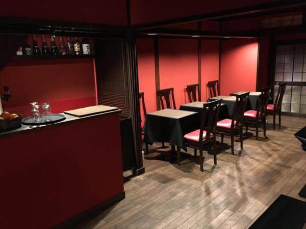 金泽金泽艾特苏士餐厅和旅馆的一间设有桌椅和红色墙壁的餐厅