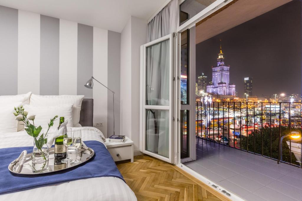 华沙GLAM APARTMENTS city center的一间卧室设有大窗户,享有城市景观