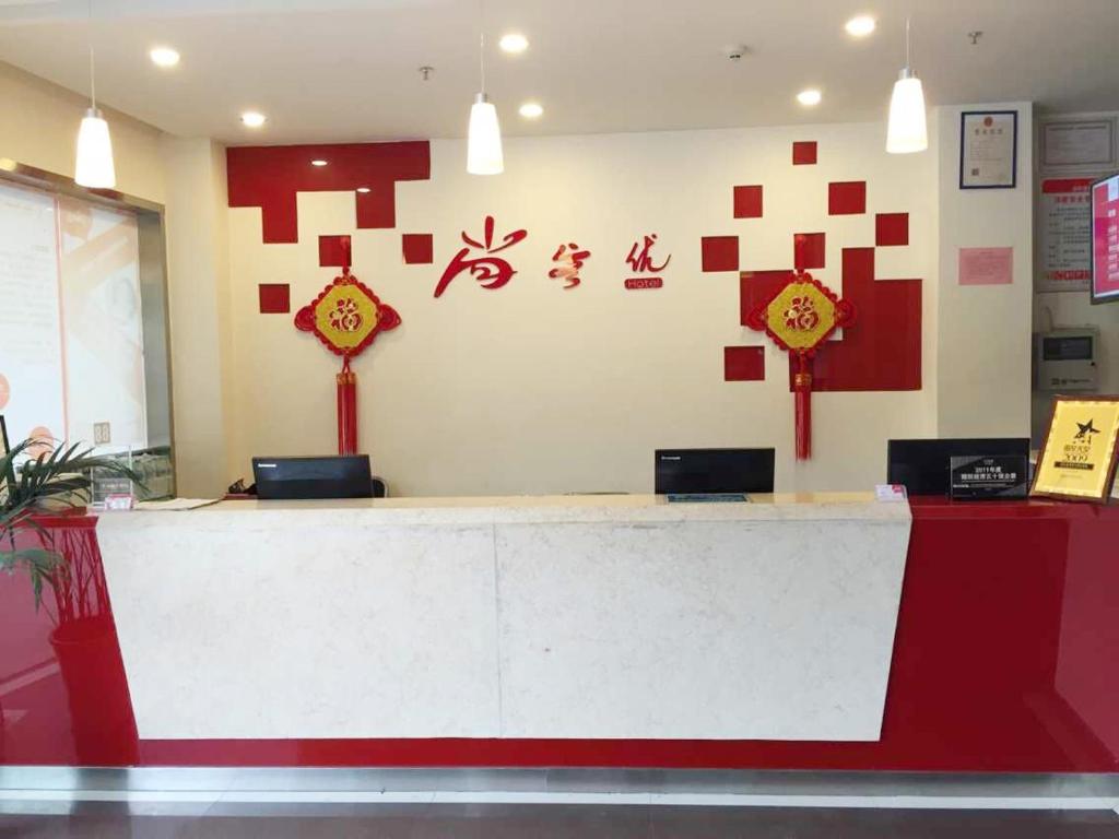 Fengxin尚客优连锁江西宜春奉新冯川东路黄泥巷店的餐厅里的一个红白柜台