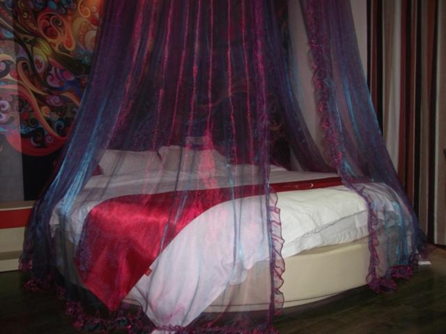 滨州尚客优连锁山东滨州汽车总站店的床上挂着窗帘的床