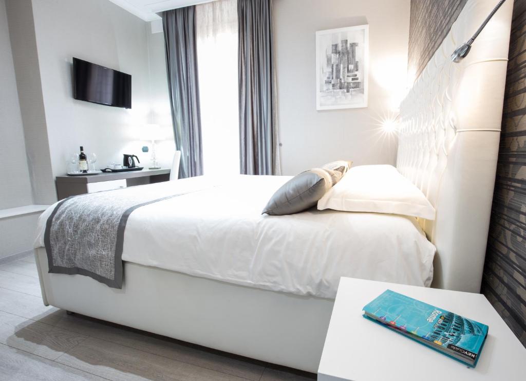 罗马雅邦岛住宿加早餐旅馆的白色卧室配有床和桌子