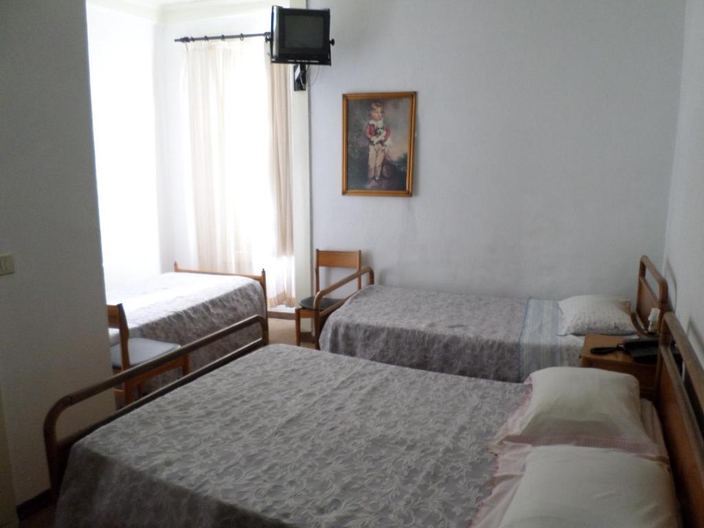 维拉·雷阿尔Rustico & Singelo - Hotelaria e Restauração, Lda的酒店客房设有三张床和电视。