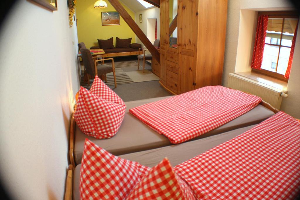 爱尔福特Pension Kronenburghof的一间房间,地板上配有四个红色和白色枕头