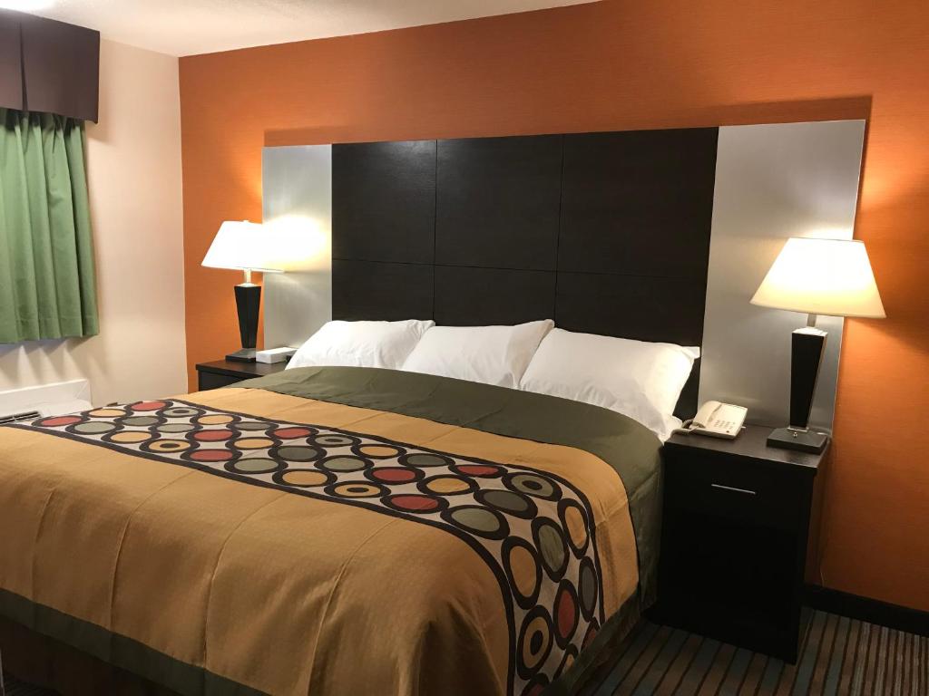 Neepawa湾丘宾馆及套房的一张大床,位于酒店带两盏灯的房间