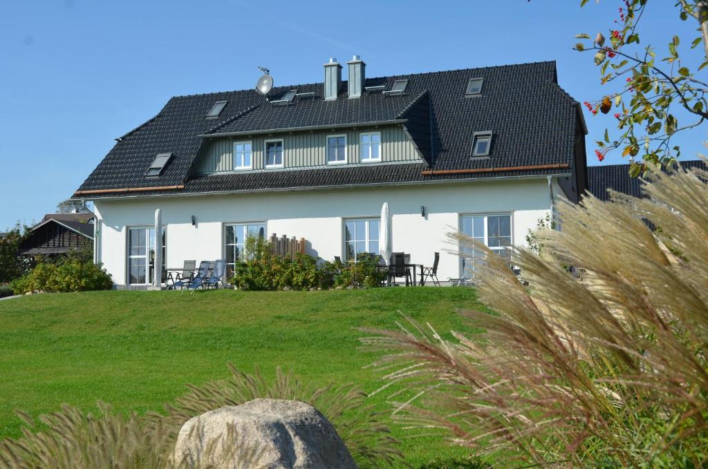 奥特里德维茨Haus Mönchgut - Haushälfte 2 "Findling"的黑色屋顶的大型白色房屋