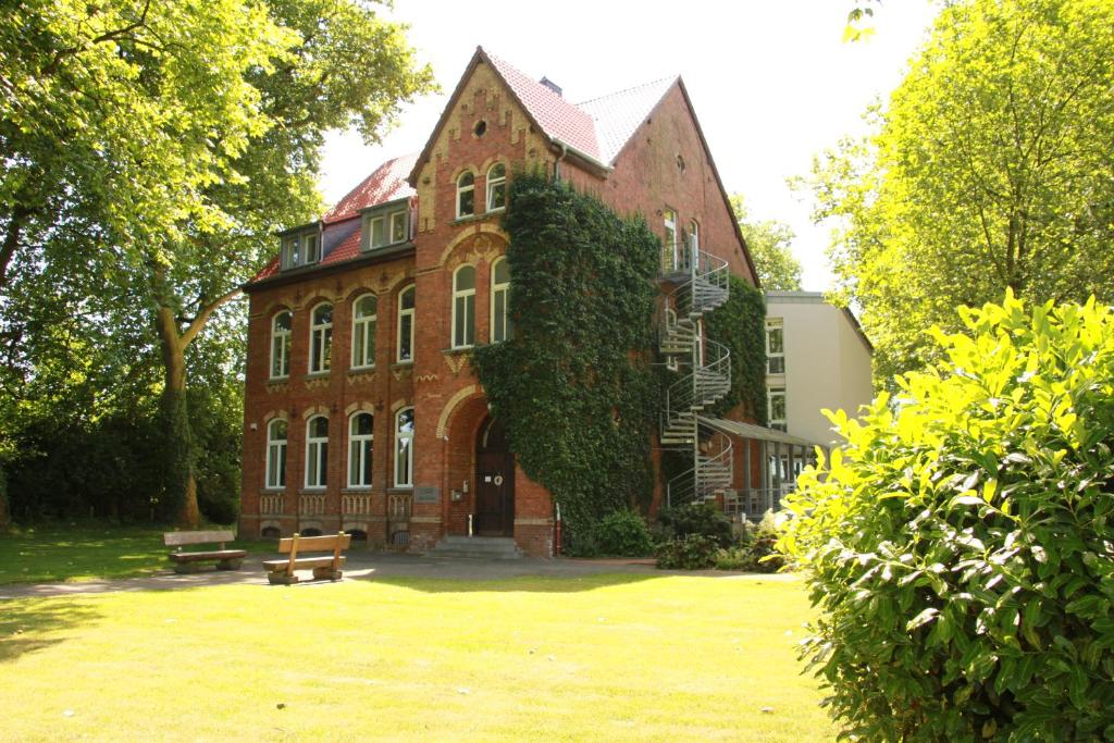 雷克林豪森Gästehaus Alte Schule的一座长着常春藤的大砖房