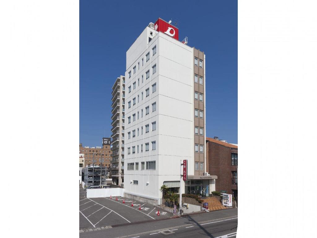 尾道市尾道第一酒店的一座白色的建筑,上面有红色的屋顶