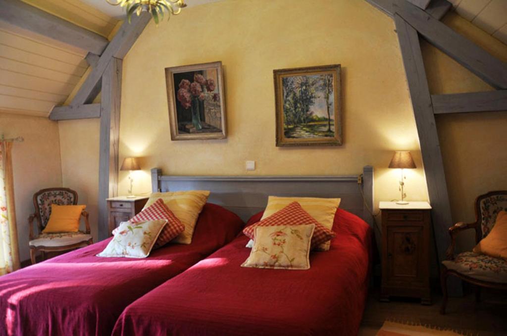 Camon赫尔迪谷仓酒店的一间卧室配有两张带红色床单和枕头的床。