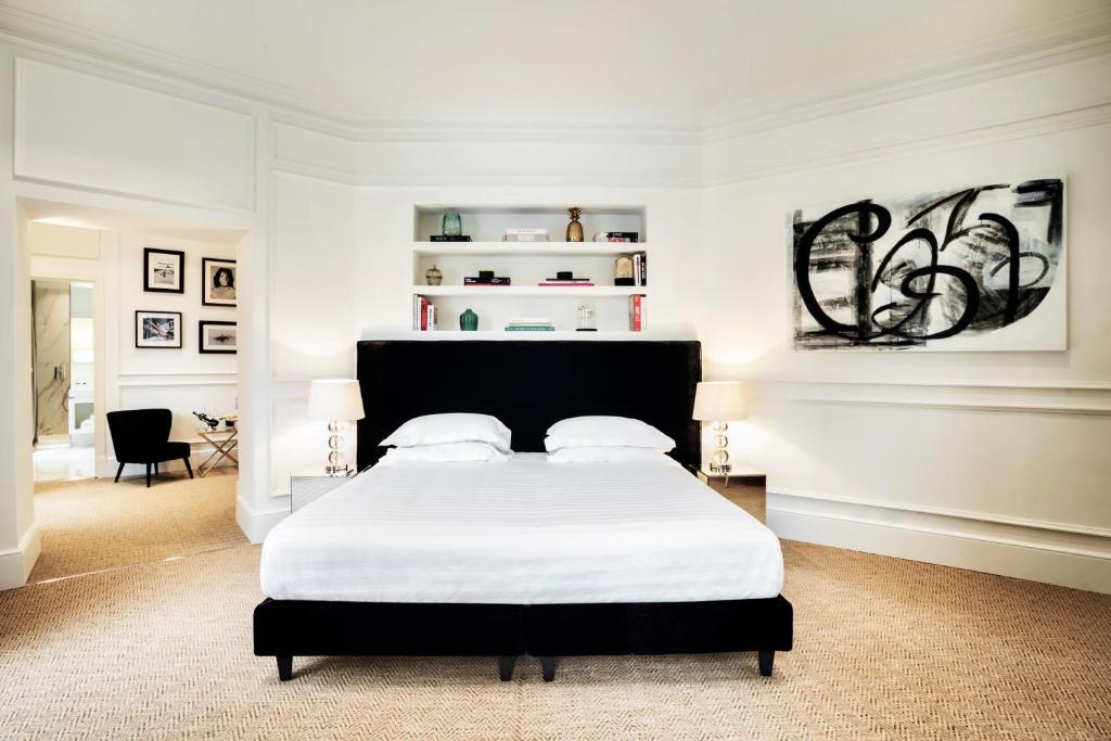 罗马希尔酒店的一间卧室配有一张带白色床单的大床