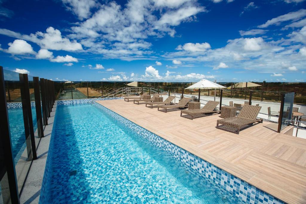 卡博迪圣阿戈斯蒂尼奥Intercity Suape Costa Dourada的一个带椅子的游泳池和一个美景甲板