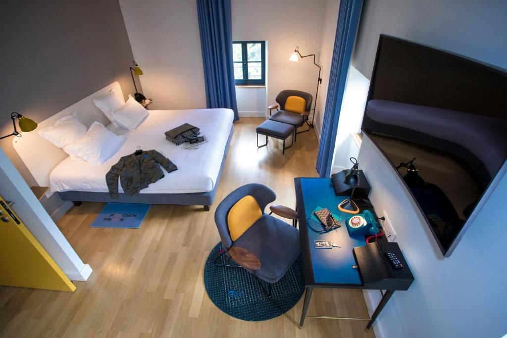 里昂富维耶酒店的卧室配有一张床和电视,享有风景。