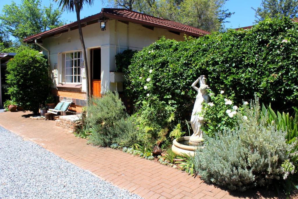 逊邱伦Grace Accommodation Centurion的房屋前带雕像的花园