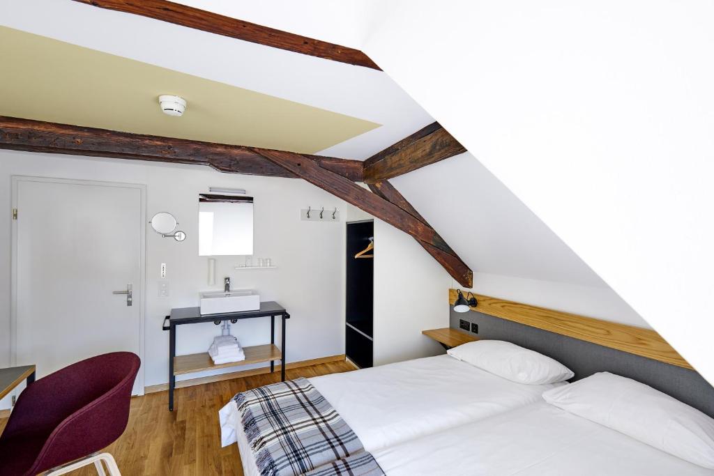 拉珀斯维尔-约纳雅各布酒店的卧室配有一张床和一张桌子及椅子