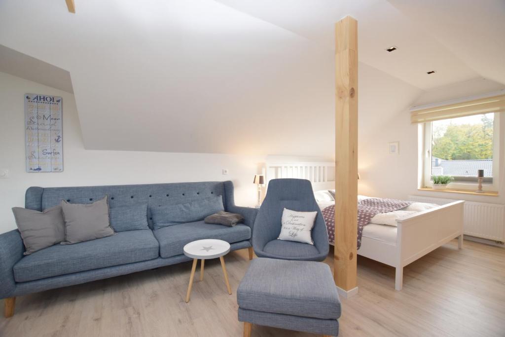 格吕克斯堡Ferienwohnung Ostseelys的客厅配有蓝色的沙发和床。