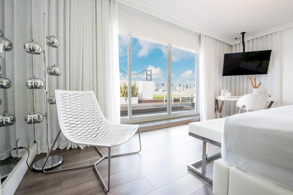 迈阿密海滩总统大酒店的一间卧室配有一张床、一张桌子和一把椅子