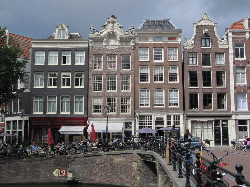 阿姆斯特丹Luxury Prinsengracht Canal House Jordan Area的桥上一些有桌子和自行车的建筑物
