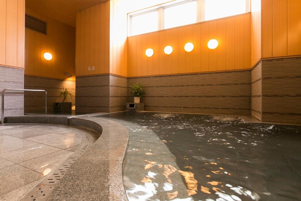 北九州西铁小仓酒店 的一座带窗户的建筑里的一个水游泳池