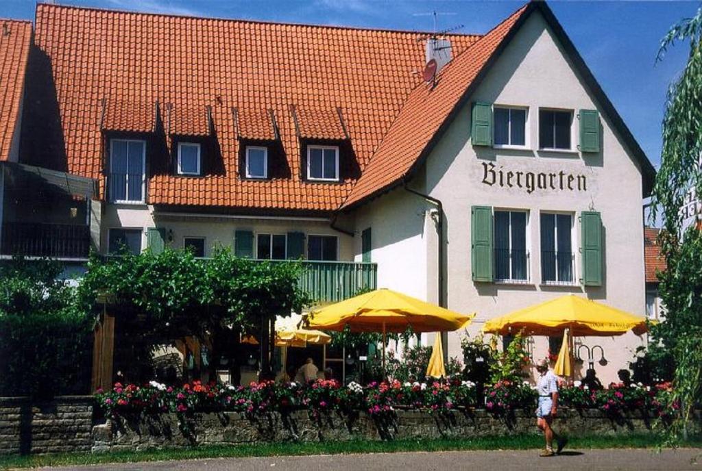 WipfeldGästehaus Zehntgraf的站在一座黄色雨伞的建筑前的人