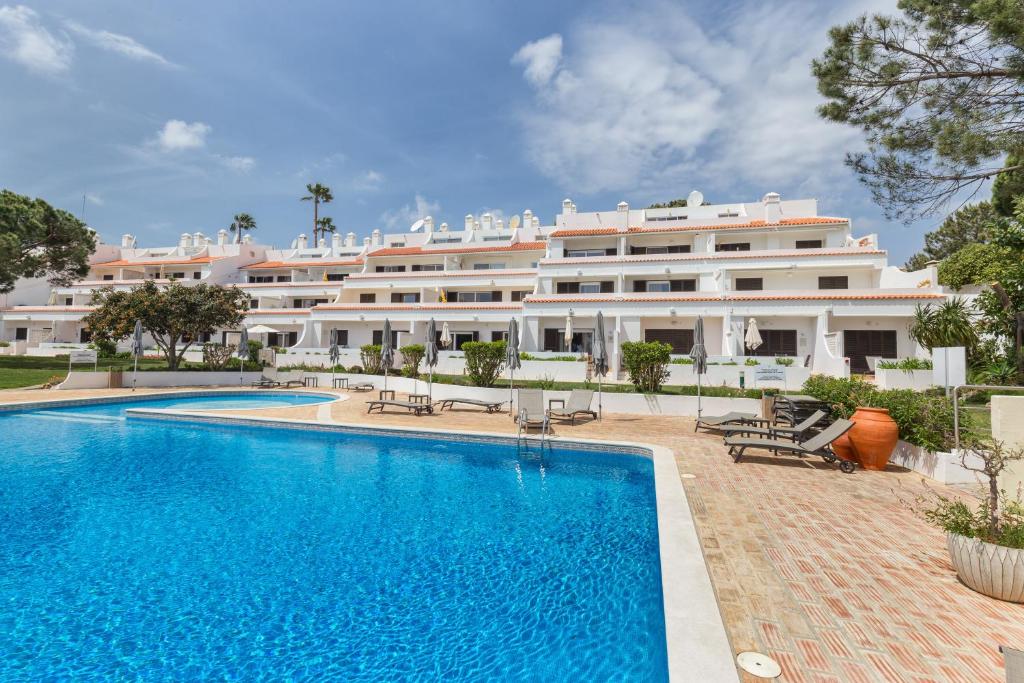 金塔湖Apartamentos Valverde - Quinta do Lago的大楼前设有游泳池的酒店