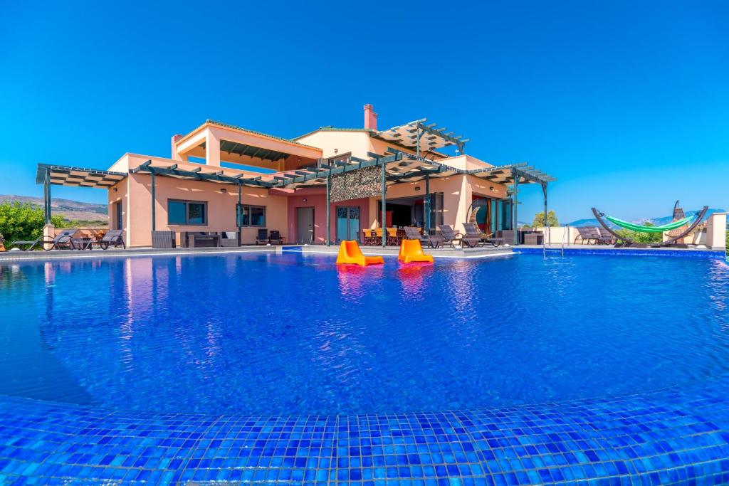 ChavriátaSkinos Ilivatos Eco Villa & Estate的一座房子前面的蓝色海水游泳池