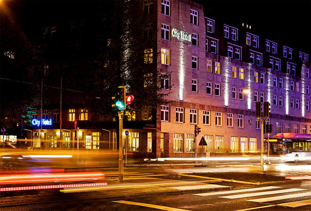 厄勒布鲁厄勒布鲁城市酒店的城市街道上夜间交通的建筑物