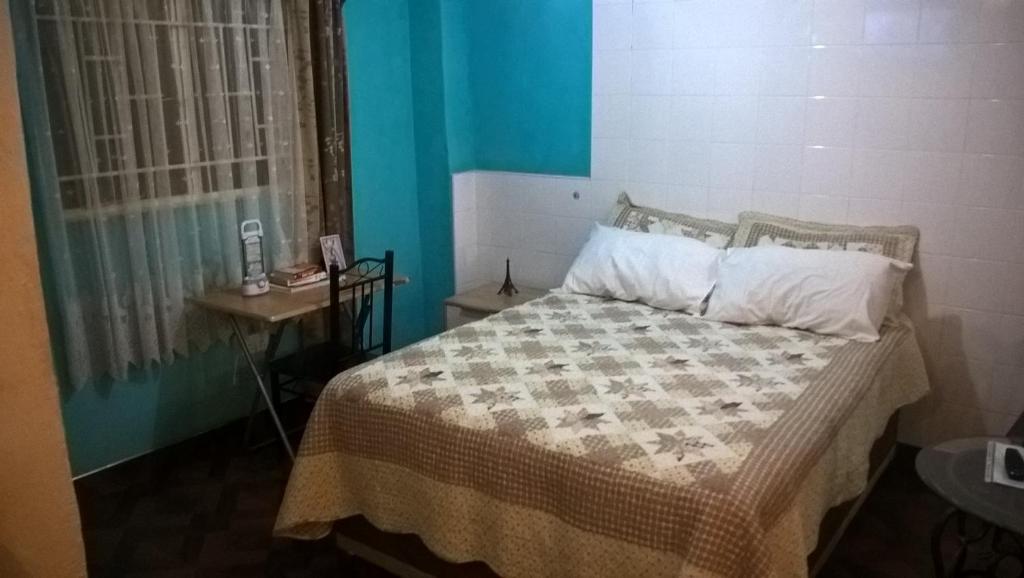 卢萨卡Furnished self-catering guest wing的一间卧室配有一张床、一张桌子和一个窗户。