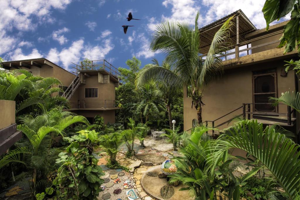 帕伦克Villas Adriana, Palenque的鸟飞过房子前面的花园