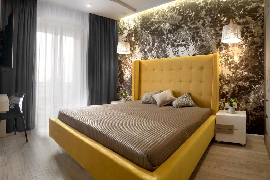敖德萨Sunny Belle Apartments的一间卧室配有黄色的床和黄色床头板