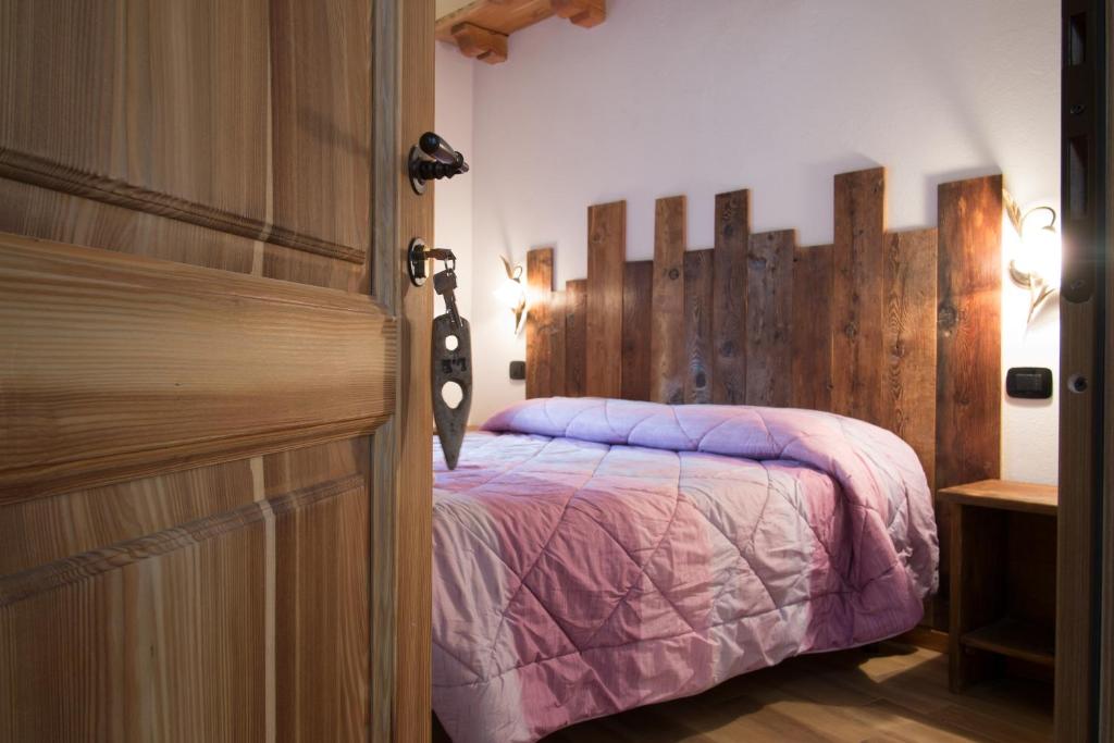 圣皮埃尔B&B Lo VAN - Camere al Verde Villaggio di Rumiod的一间卧室配有一张床和一扇木门