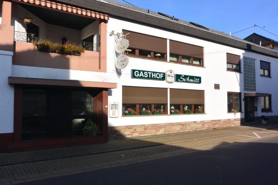 梅尔齐希Gasthof Schmitt的白色的建筑,旁边标有标志